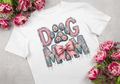 White graphic tee with Dog Mom floral patchwork letters, paw print, and pink satin bow with pearl detail, styled with pink tulips